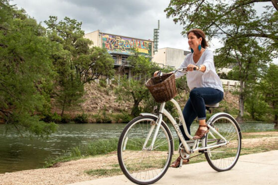 woman riding bike along river