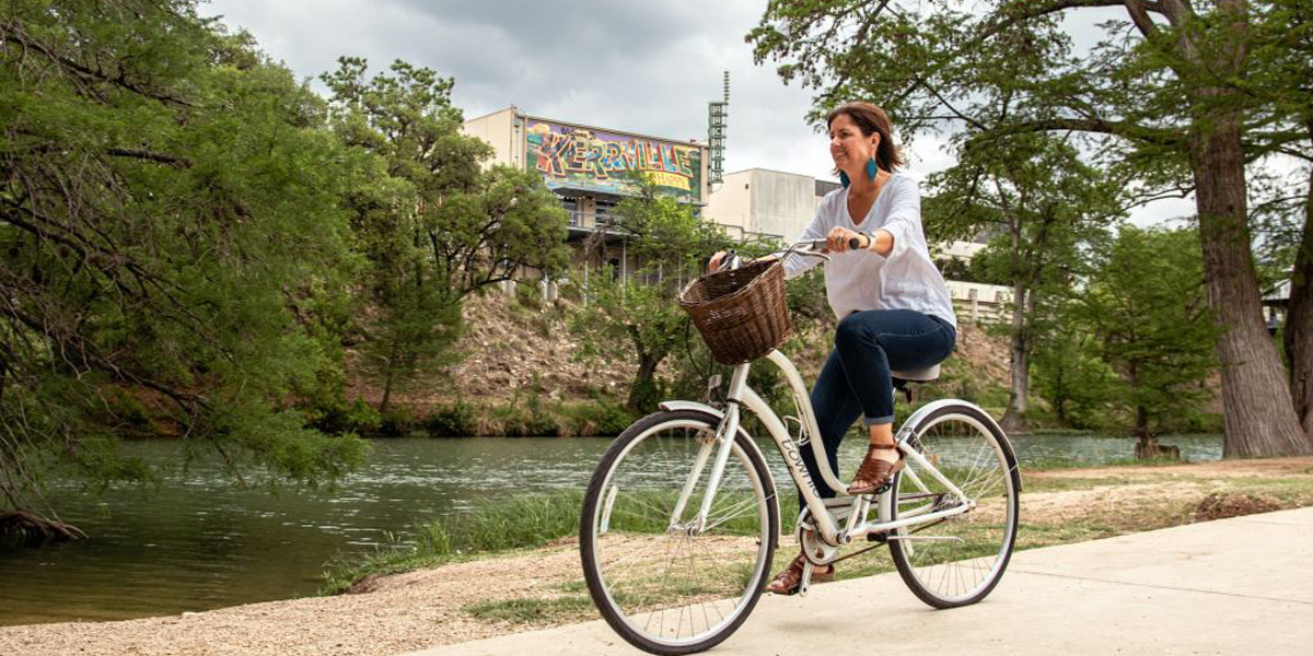 woman riding bike along river