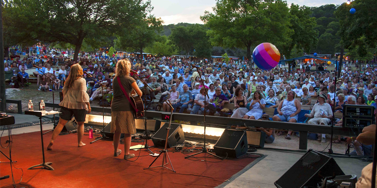 Sara Hickman and Kristin DeWitt perform before a packed audience at the Kerrville Folk Festival. Photograph by Susan Roads, Courtesy Mary Muse, Kerrville Folk Festival Foundation.