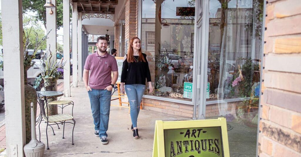 Couple strolling down sidewalk in Kerrvile, Texas