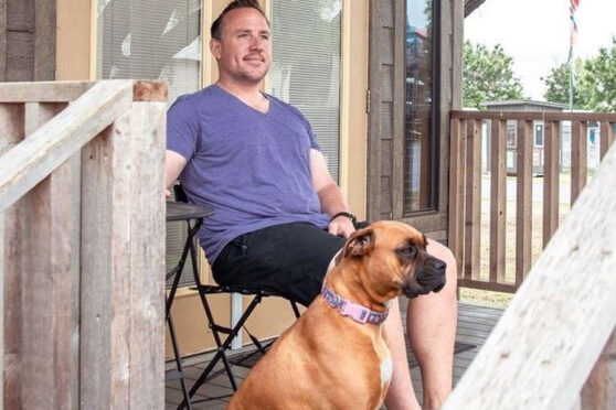 Man sitting with dog on porch