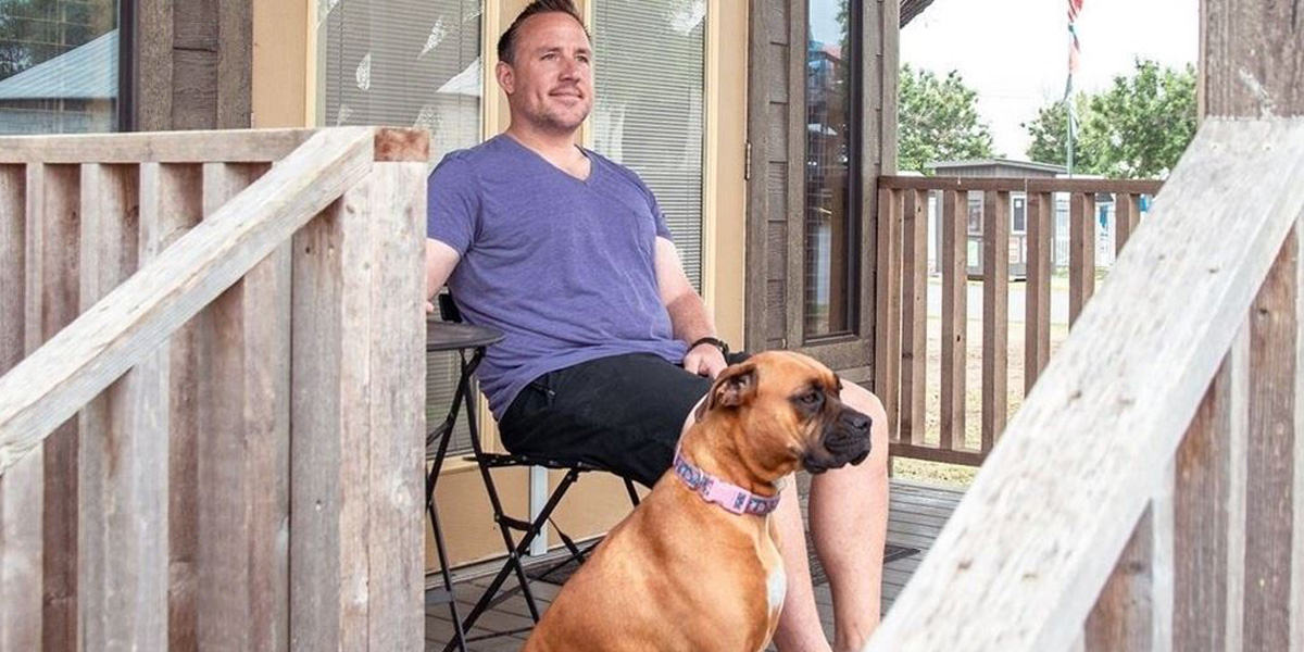 Man sitting with dog on porch