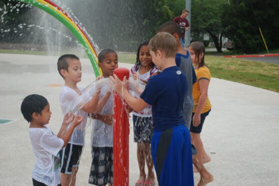 Kids playing at Carver Park Sprayground fountain
