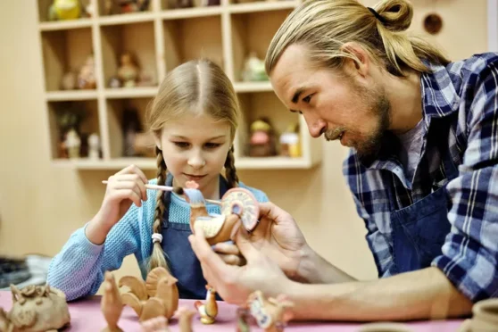 Student and teacher painting pottery