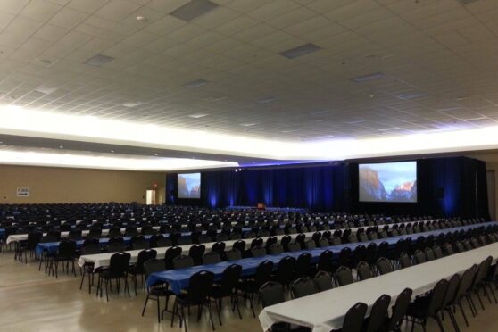 Event room set up with several rows of chairs and tables for an event