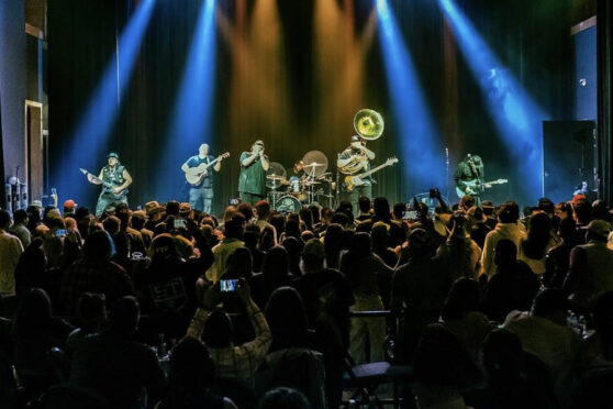 Concert at The Arcadia Live with band on stage and audience watching.