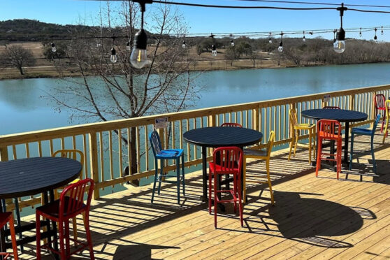 The Boat patio by river with tables and chairs