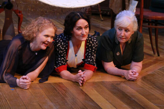 Three women lying on stage for a stage production