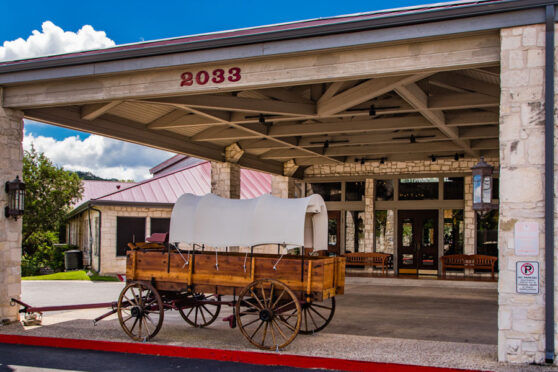 Entrance of the Y.O. Ranch with a replica of an old pioneer covered wagon situated in the circle drive