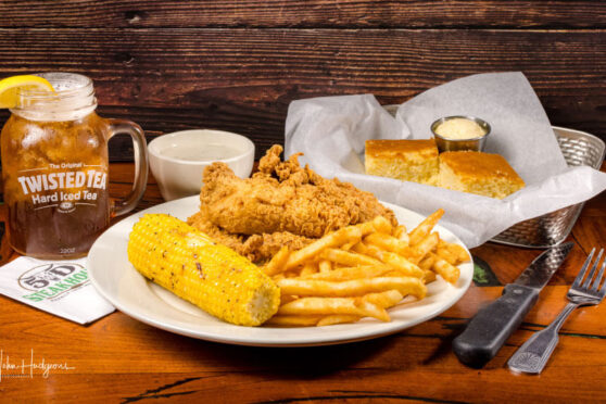 Fries and chicken served with con and bread.