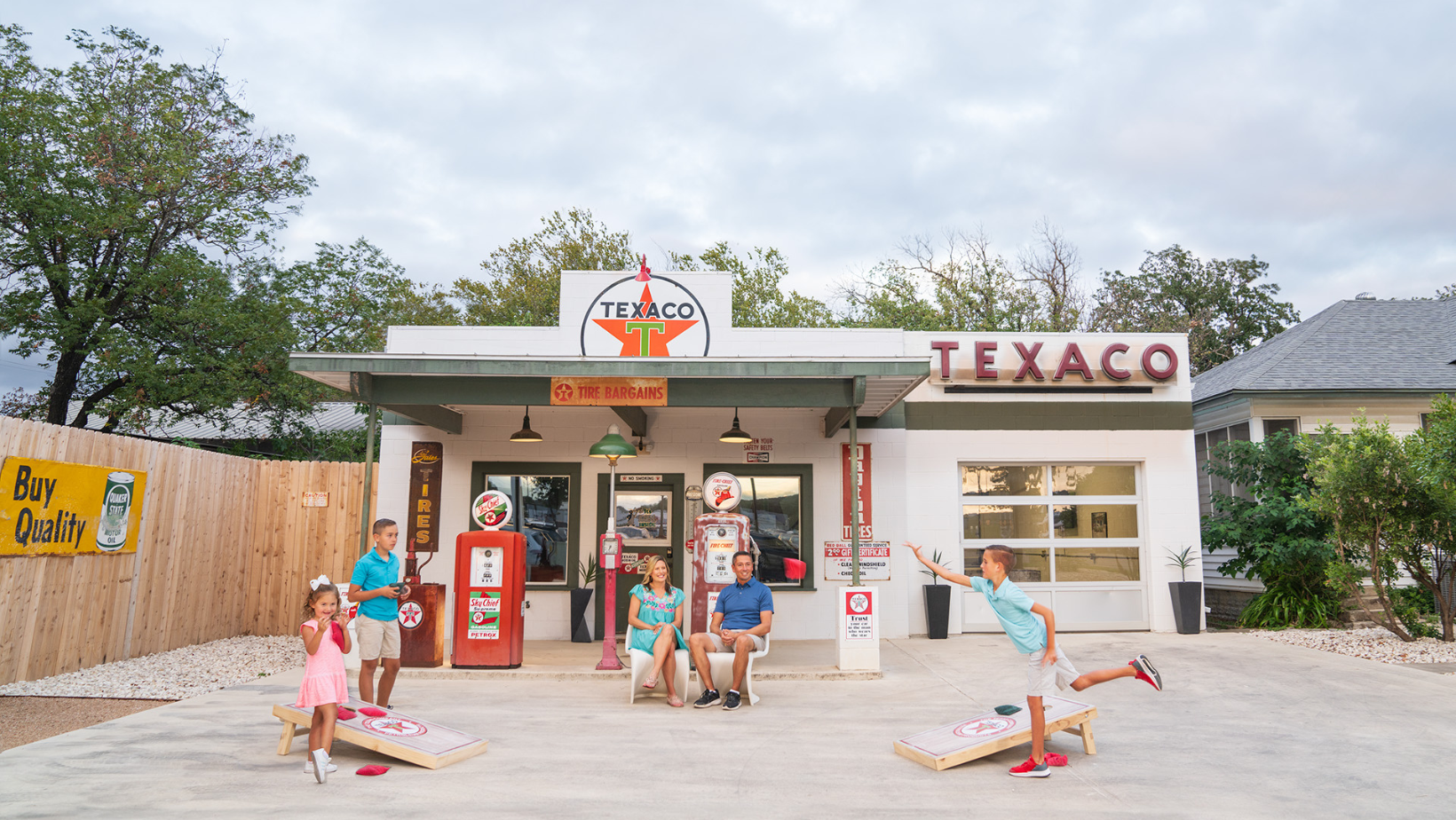 Family playing cornhole in fornt of Texaco Airbnb