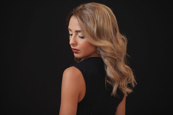 Woman with styled hair, service done at Hair Productions.