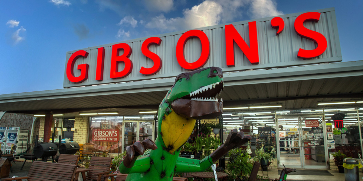 Gibson's storefront with metal dinosaur in front of building