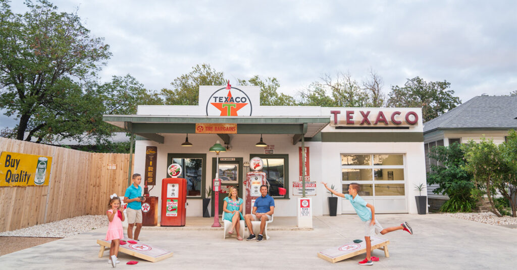 Texaco Airbnb with family relaxing in front of gas pumps