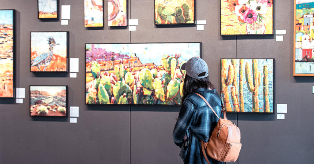 A woman viewing art on the wall.