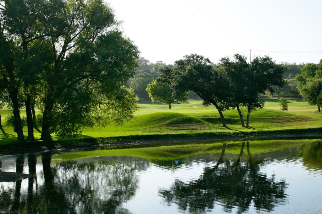 Lush green Scott Schreiner Golf course with trees and water feature