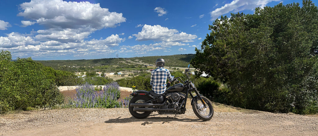 Guy sitting on motorcycle at rest stop overlooking the Texas Hill Country landscape