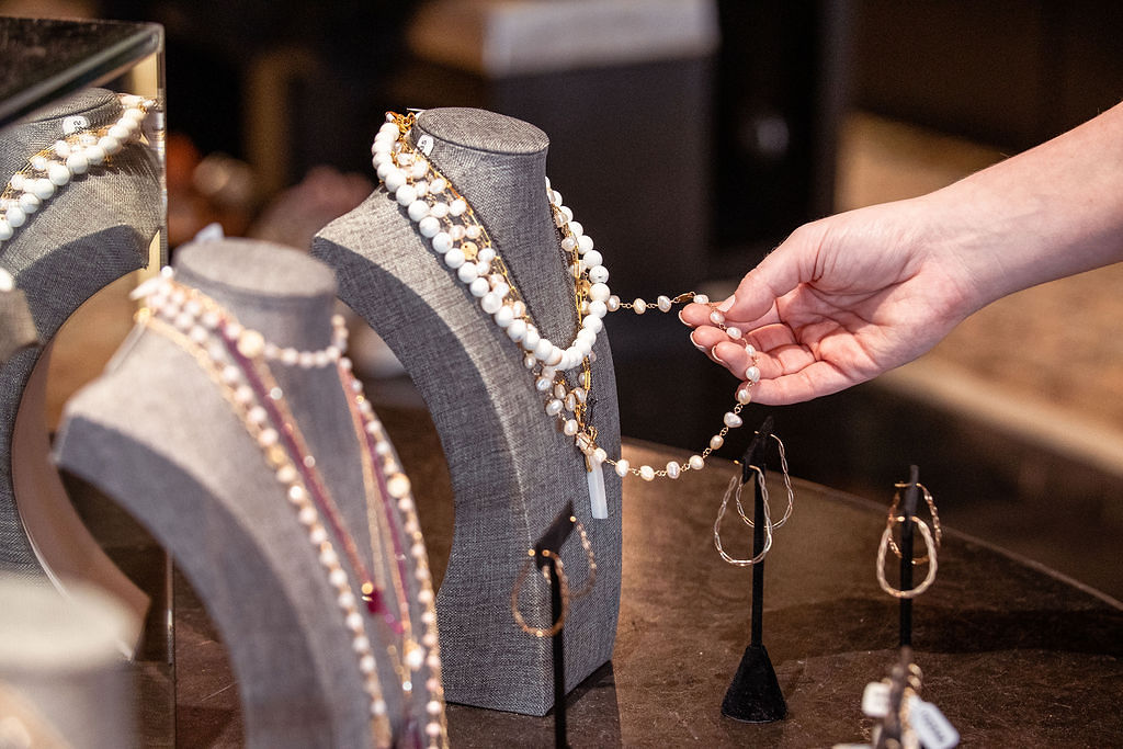 Woman's hand touching jewelry on display at a local shop in Kerrville