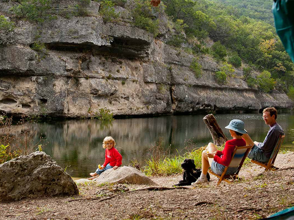 Family Camping near river outside a tent at Lost Maples State Natural Area - Photo Credit-Texas Parks and Wildlife
