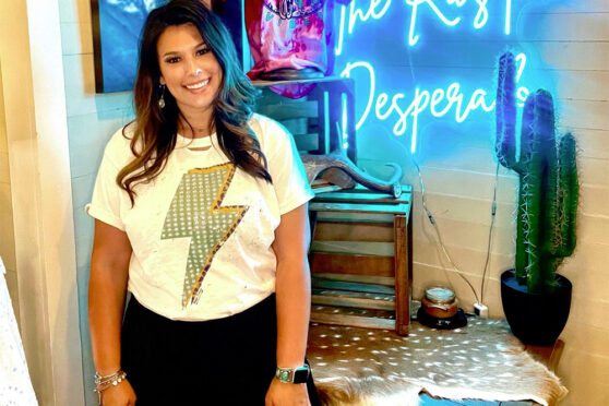 Woman posing next to The Rustic Desperado neon sign