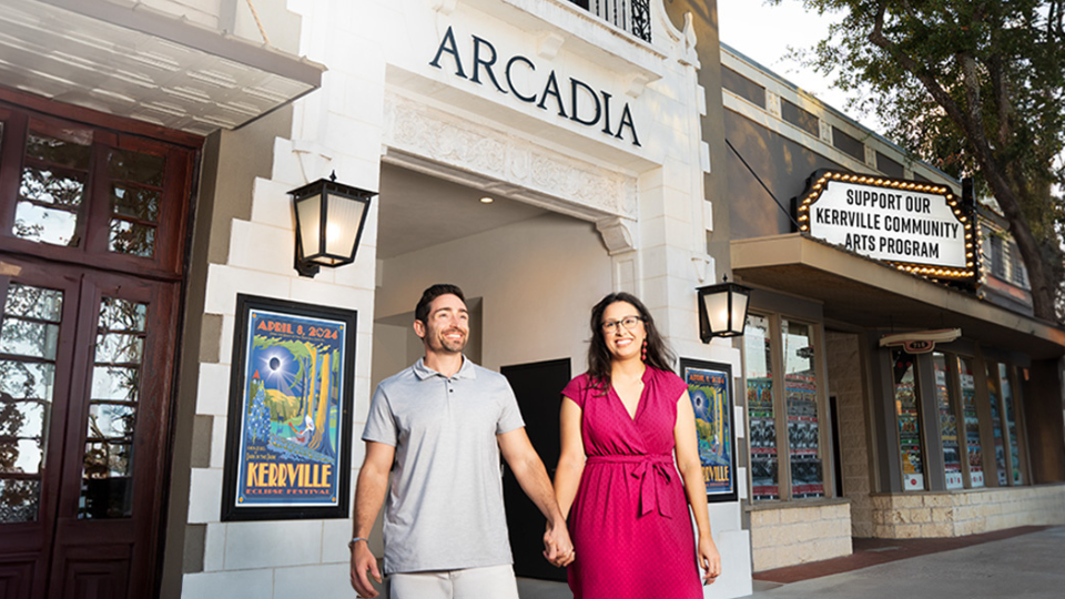 a couple holding hands in front of Arcadia in Kerrville