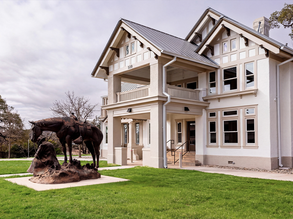 A historic home with a bronze statue out front