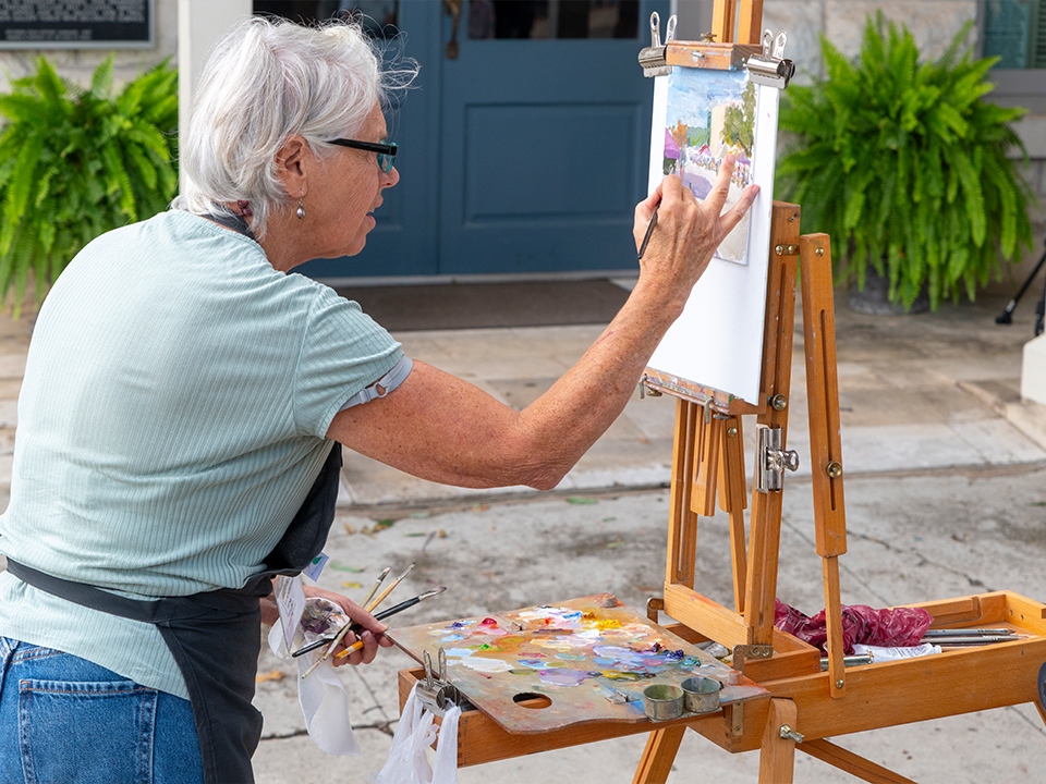 Person waiting on an easel in an outdoor city setting